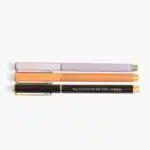 Plumas para mujer en forma horizontal con frases motivacionales de tres colores morado, naranja y negro