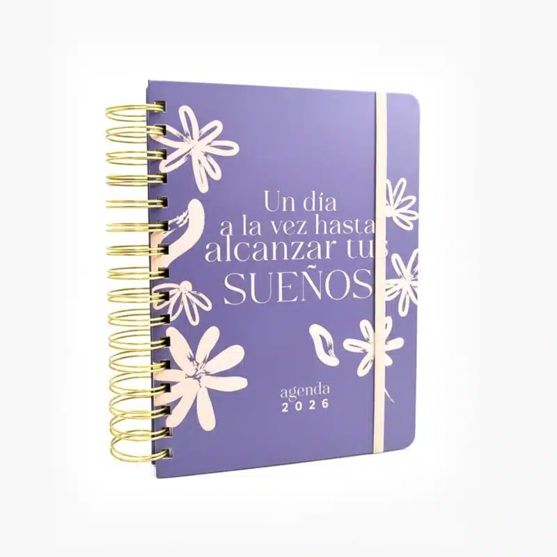 Agenda sencilla 2026 azul con frase motivacional "Un día a la vez hasta alcanzar tus sueños" y espiral dorado.