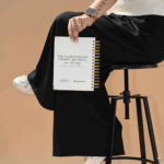Contraportada blanca de la agenda Planifesting 2026 verde sostenida por una mujer, con frase motivadora en verde.