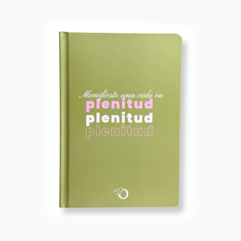 Libreta color verde con la frase "Manifiesto una vida en plenitud" en tipografía rosa y blanca.