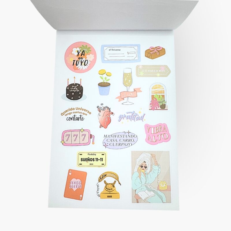 Hojas de stickers con mensajes como Querido universo, gratitud, vibrar alto, sueños 11:11 y símbolos de abundancia del libro Me quiero un chingo.